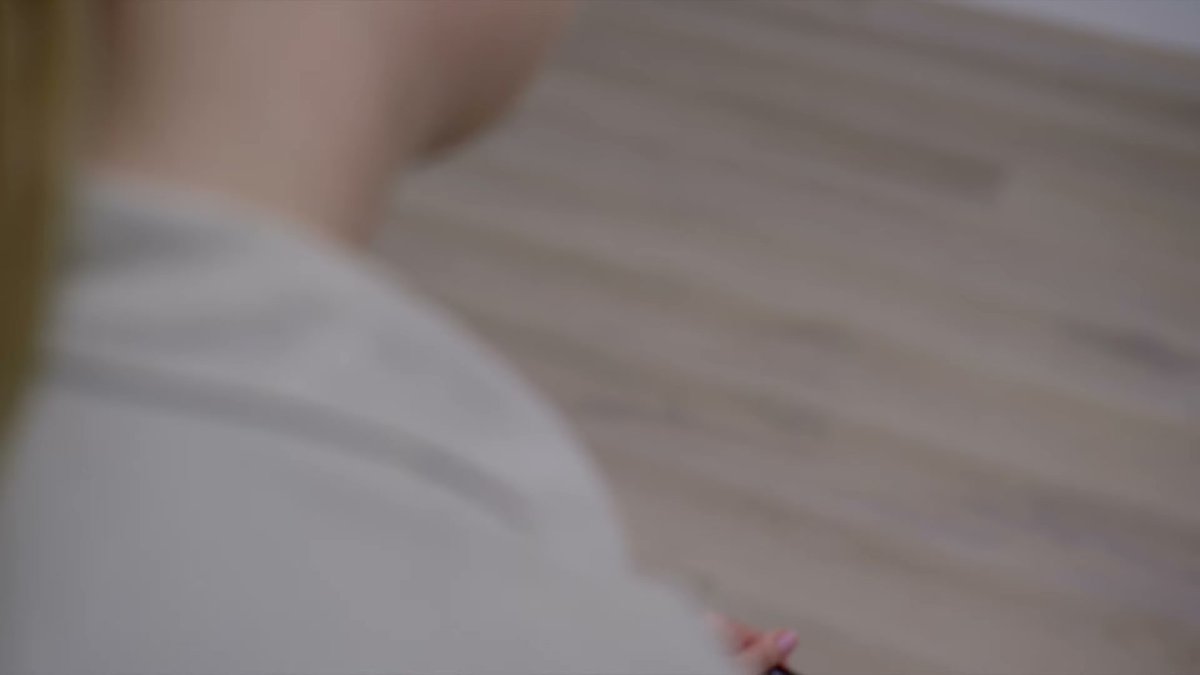 Dyson Gen5detect in use on hardwood floor, partial view of user