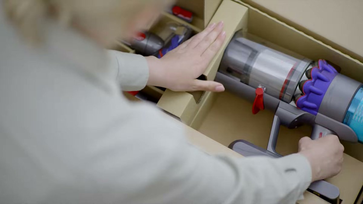 Person unboxing Dyson Gen5detect vacuum with accessories visible