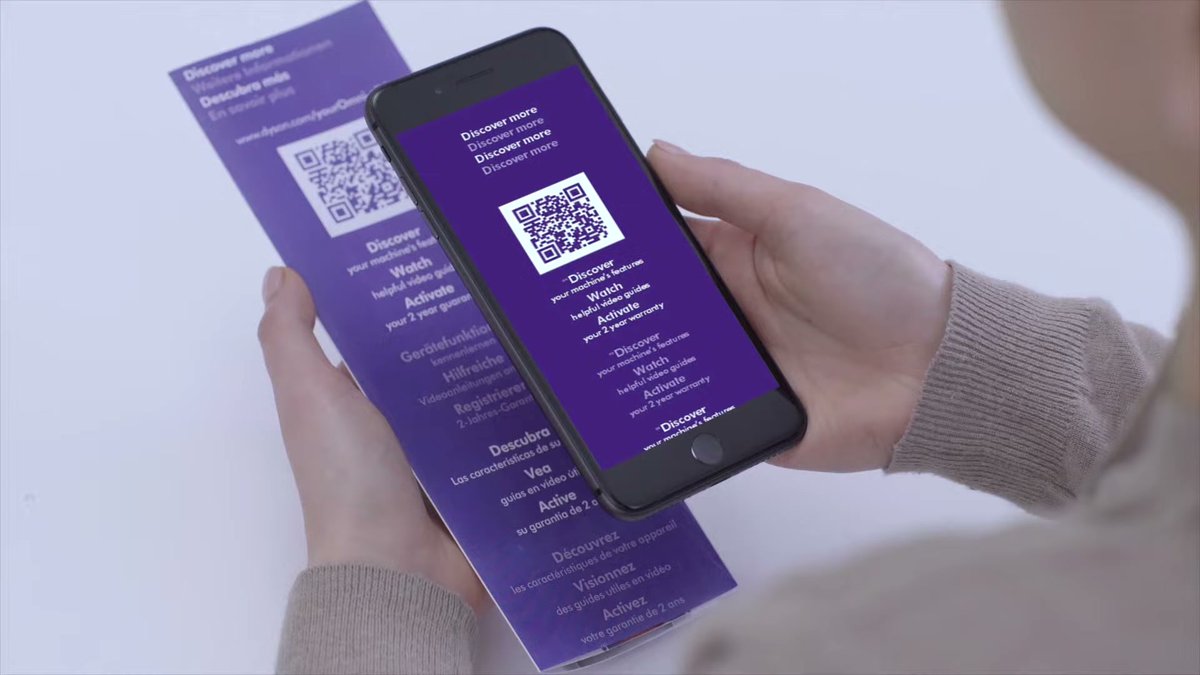 Person using smartphone to scan QR code on Dyson Omni-Glide accessory card