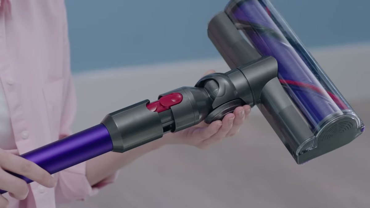 Close-up of Dyson V11 Torque Drive handle and nozzle being held during use