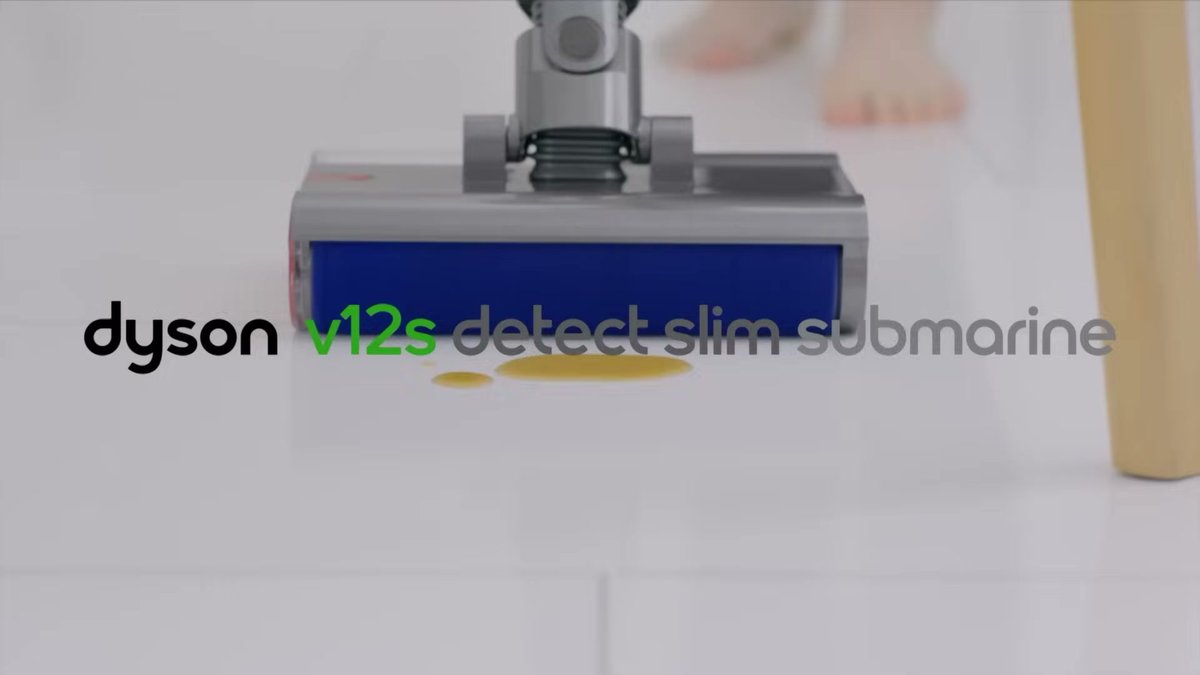 Dyson V12 Detect Slim vacuum cleaning a spill on hardwood floor with laser illumination