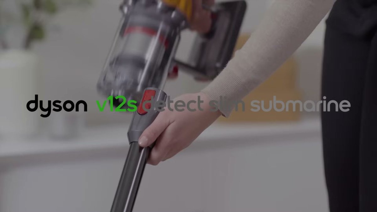 Person holding Dyson V12 Detect Slim vacuum in a home setting