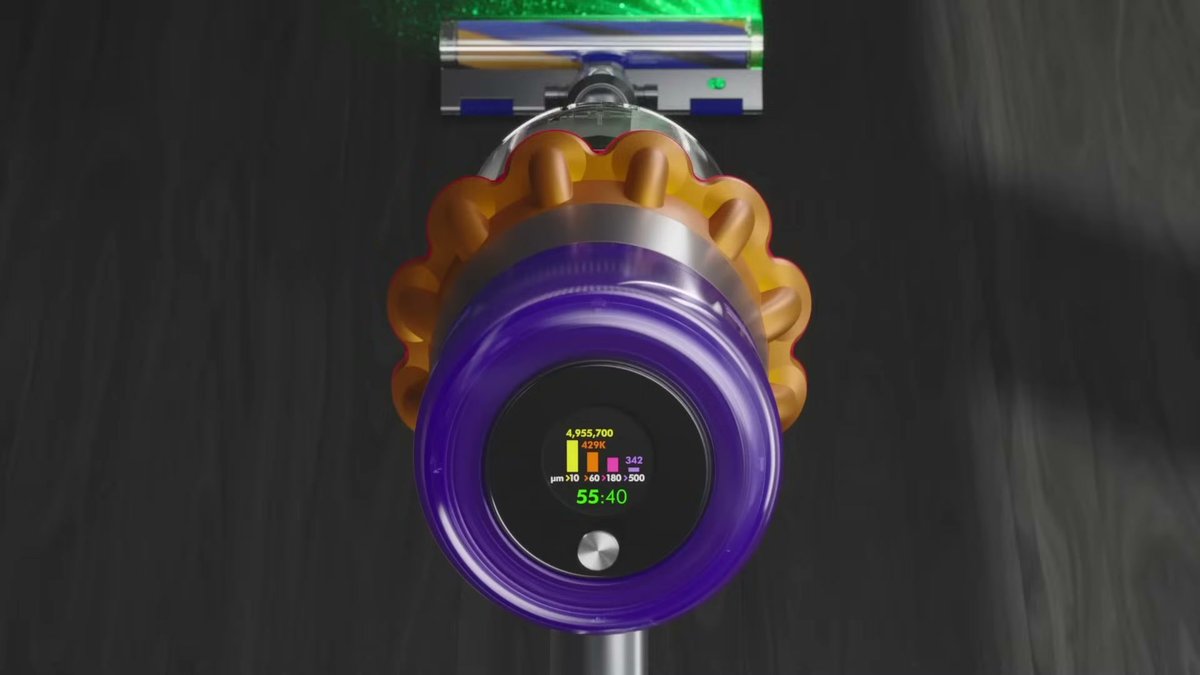 Dyson V15 Detect Absolute showing laser dust detection and particle count display on hardwood floor